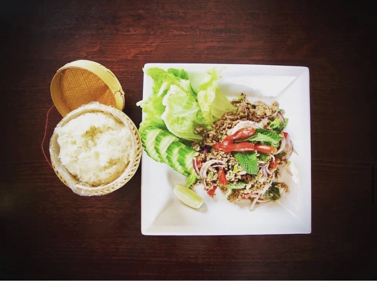 A spicy herb salad and sticky rice prepared at Sara Thai